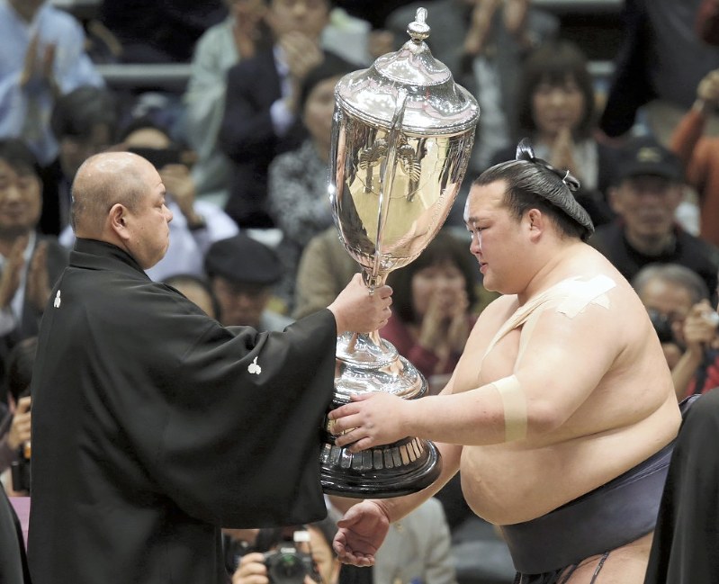 2017年春場所で大けがを押して優勝し、日本相撲協会の八角理事長(左)から賜杯を受け取る稀勢の里=エディオンアリーナ大阪で同年3月26日、貝塚太一撮影