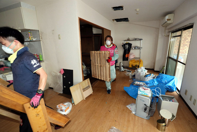 大阪北部地震で、水道管が破裂したマンションの部屋から家具などを運び出すボランティアたち=大阪府吹田市で2018年6月23日、幾島健太郎撮影