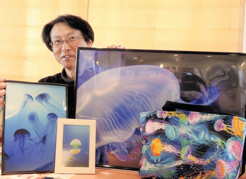 写真や手作りバッグをはじめ、クラゲにまつわるグッズを見せる平山博文さん=東京都町田市で、梅田啓祐撮影
