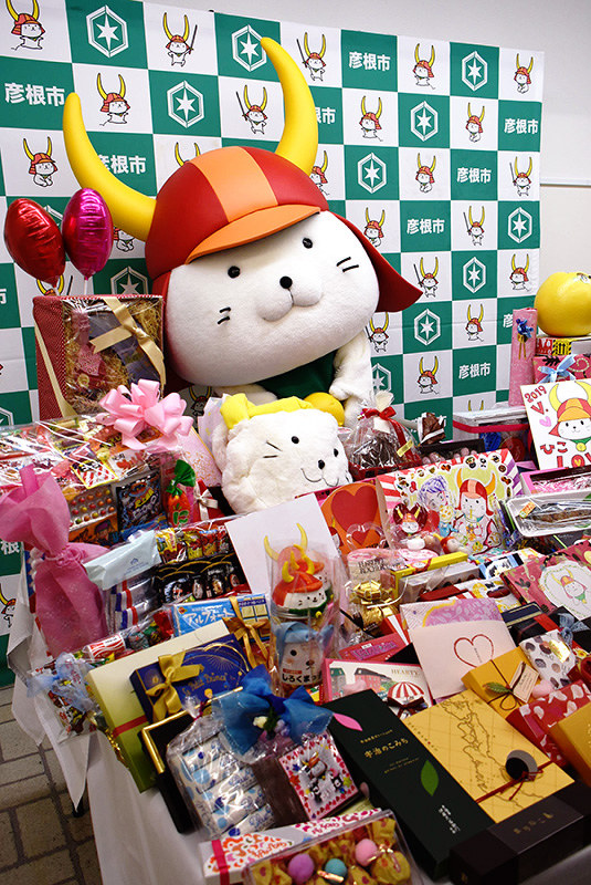 たくさんのバレンタインプレゼントに囲まれて喜ぶひこにゃん=滋賀県彦根市役所で