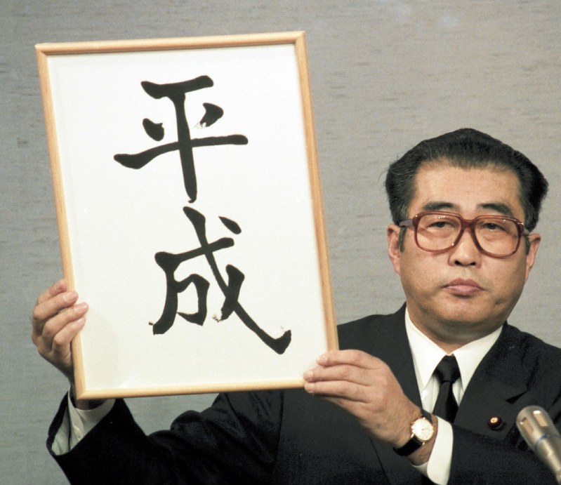 「平成」と書かれた額を掲げて、新元号を発表する小渕恵三官房長官=首相官邸で1989年1月7日撮影
