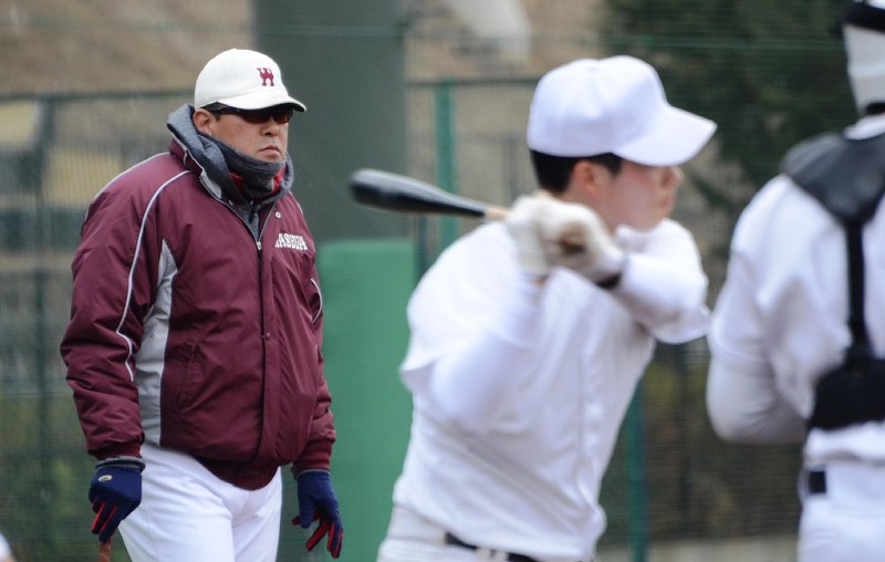 練習中に厳しい視線を送る小宮山悟監督(左)