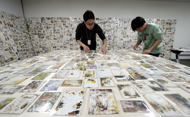 東日本大震災の被災地・宮城県山元町で見つかった写真をボードに並べる大学生たち=大阪府吹田市で2019年2月22日午後3時25分、幾島健太郎撮影