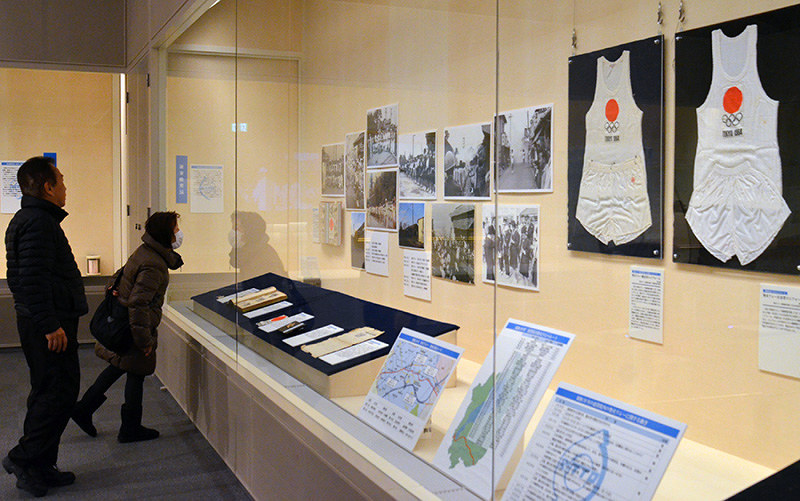 1964年の東京五輪聖火リレーで使われたランナーのユニホームなどが並ぶ館内=滋賀県栗東市小野の栗東歴史民俗博物館で、礒野健一撮影