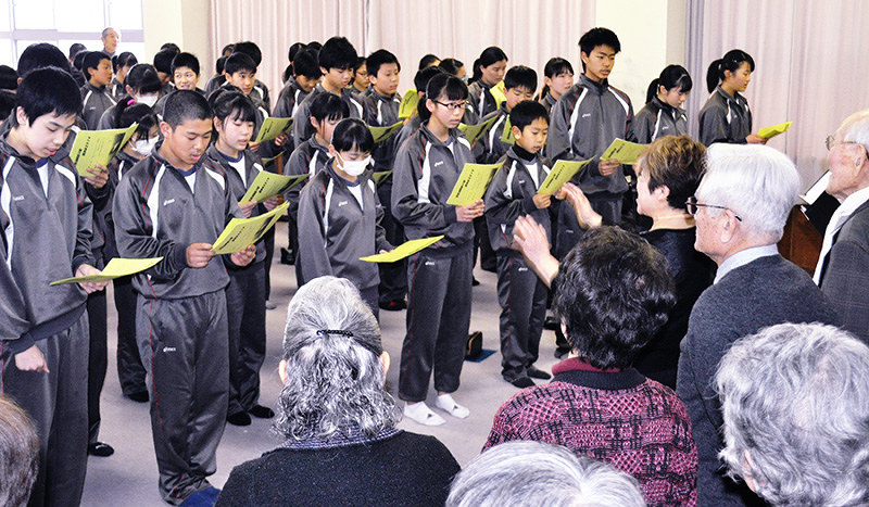 ブルーコーラスのメンバー(手前)と一緒に琵琶湖周航の歌を歌う今津中学校1年生=滋賀県高島市の同校で、塚原和俊撮影