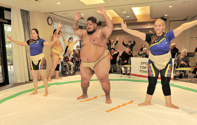老人ホームで相撲体操に挑戦し、高齢者と交流するベネズエラ選手たち=東京都世田谷区で、松本晃撮影