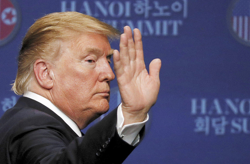 首脳会談後の記者会見で手を上げて応えるトランプ米大統領=ベトナム・ハノイで2019年2月28日、ロイター