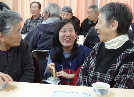 交流会で学生（中央）に感謝の気持ちを伝える住民たち