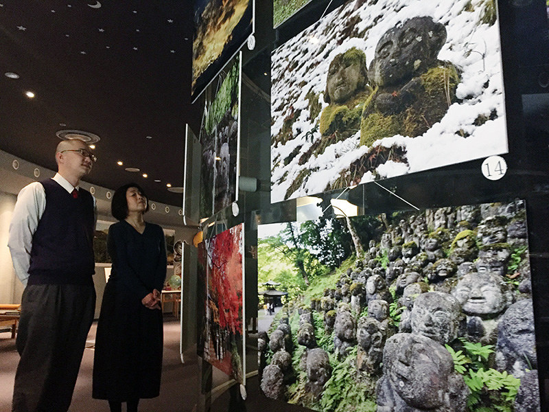 さまざまな羅漢の表情が並ぶ写真展「愛宕念仏寺と嵯峨」=京都府城陽市寺田の文化パルク城陽プラネタリウムのロビーで、今西拓人撮影