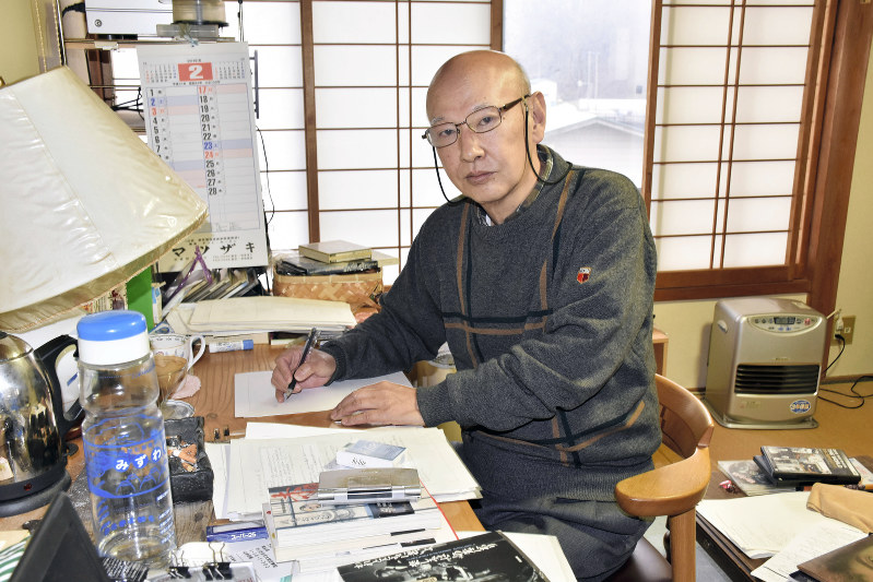 仕事場でペンを執る山本さん=福島県天栄村の自宅で、原奈摘撮影