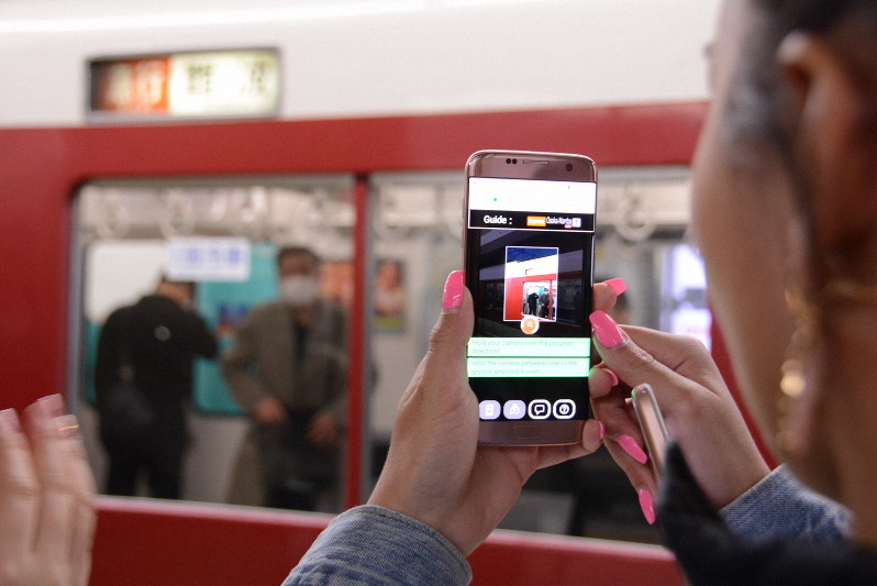 列車の行き先表示にスマートフォンをかざし、目的地に向かう列車かどうか調べるオーストラリア人の女性=奈良市の近鉄奈良駅で2019年2月22日午後2時45分、数野智史撮影
