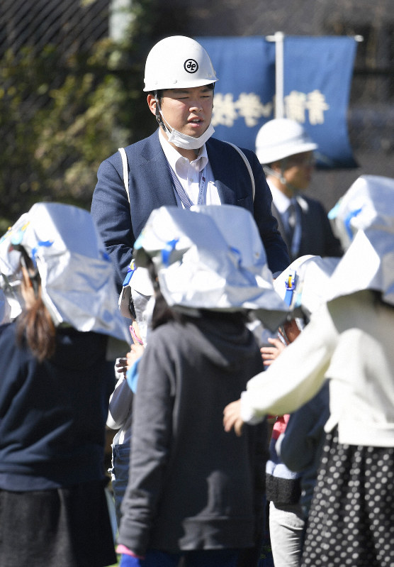 避難訓練で児童を誘導する佐々木慎一郎さん=東京都港区で2019年3月8日午前10時3分、藤井達也撮影