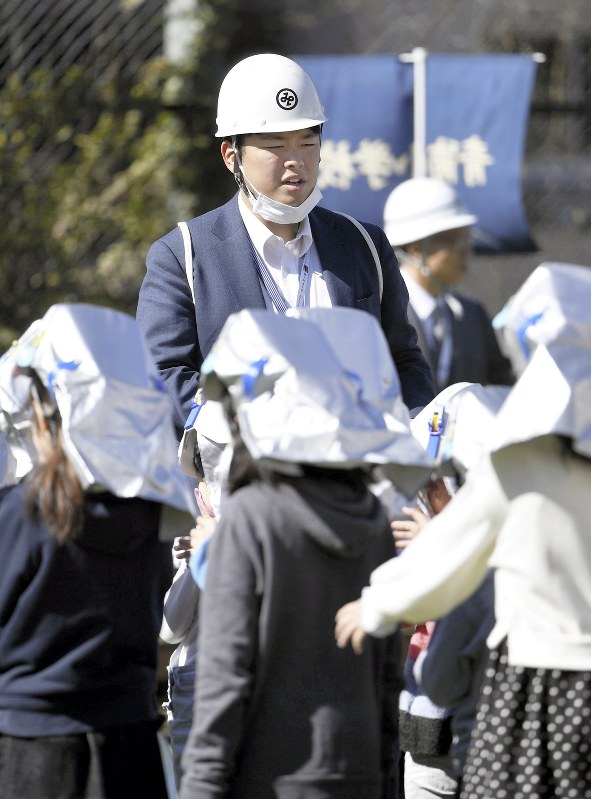 避難訓練で児童を誘導する佐々木慎一郎さん=東京都港区で2019年3月8日午前10時3分、藤井達也撮影