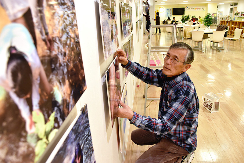 ボランティア活動の一環で東日本大震災関連の写真展の準備をする藤田敏則さん=高松市内で、山口桂子撮影