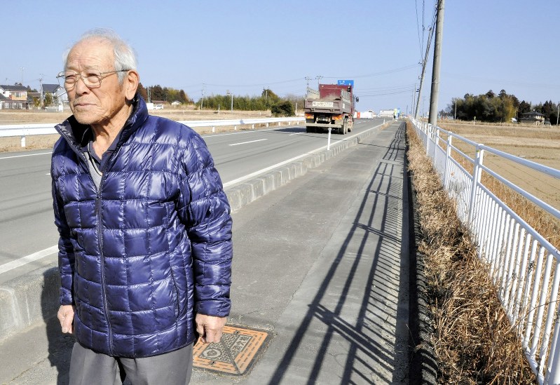東北電力浪江・小高原発の建設が計画されていた土地へと続く道路を歩く安部一さん=福島県浪江町で2019年2月5日、高橋隆輔撮影