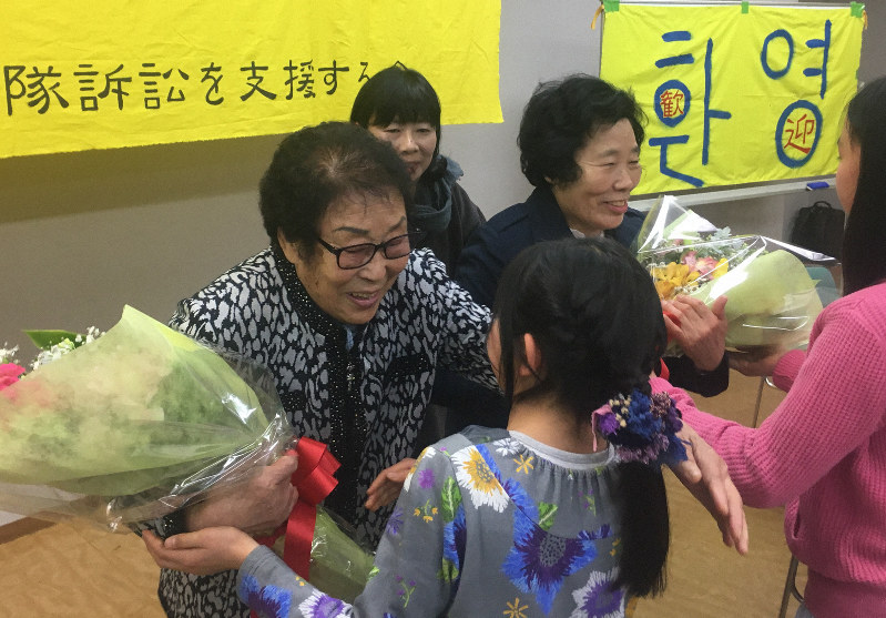 花束を受け取り笑顔を見せる、元女子勤労挺身隊訴訟の原告、梁錦徳さん(左端)と李敬子さん(その右)=名古屋市熱田区で2019年3月10日午後2時7分、野村阿悠子撮影
