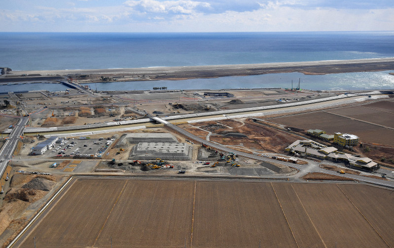 【東日本大震災8年】土地のかさ上げなどの工事が続いている閖上地区。震災で大勢の犠牲者が出た特別養護老人ホームの建物(右)は8年を経た今も残っている=宮城県名取市で2019年2月14日、本社ヘリから手塚耕一郎撮影