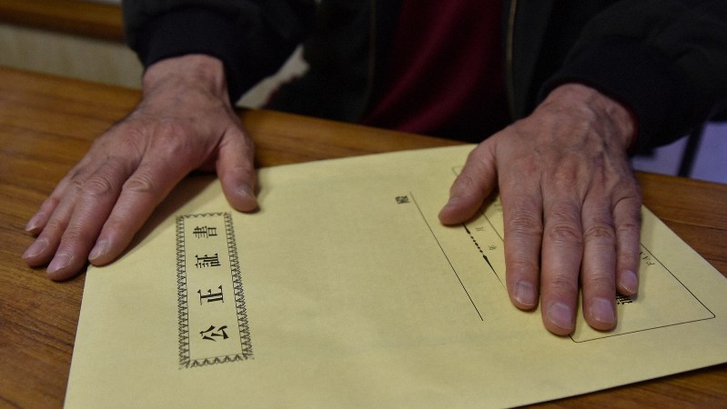 遺贈内容が記された公正証書遺言を手にする男性=埼玉県内で、筆者撮影