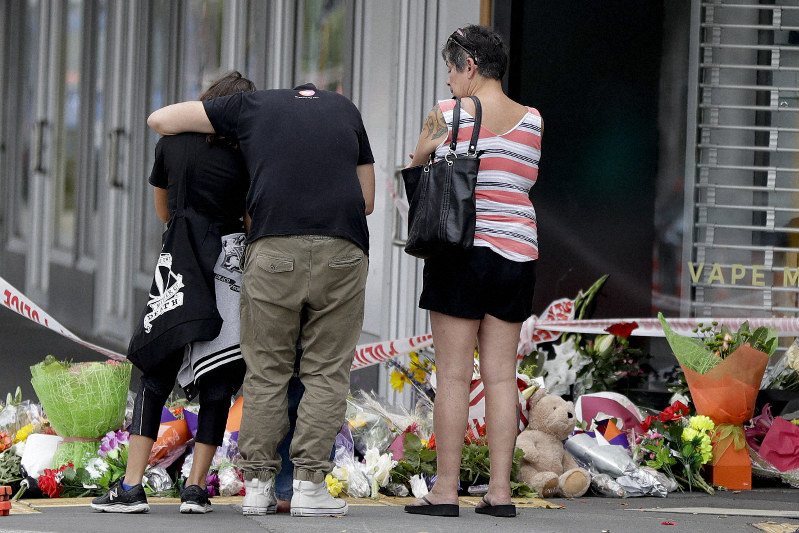 銃撃事件の現場となったモスクの前で犠牲者を悼む人々=AP