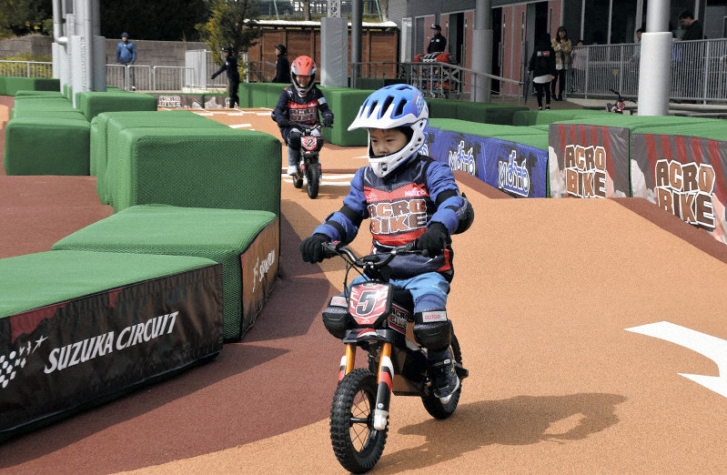 鈴鹿サーキットの遊園地「モートピア」に新設されたバイクアトラクション「アクロバイク」を楽しむ子どもたち=三重県鈴鹿市の同園で、森田采花撮影