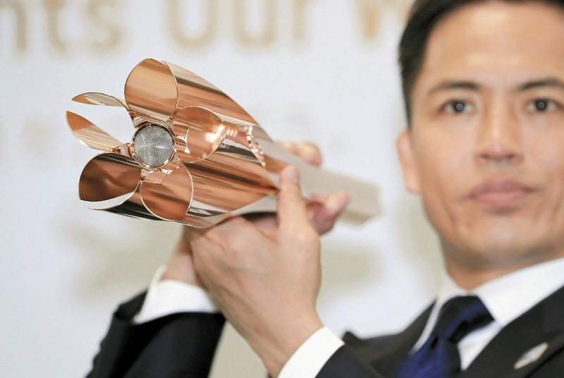東京五輪聖火リレーのトーチ。炎が出る部分が桜の花びらのデザインになっている=東京都港区で20日、梅村直承撮影