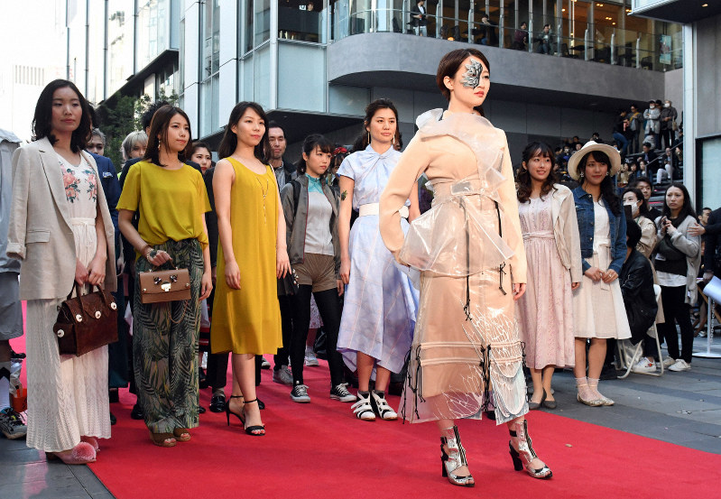 渋谷エリアのショップ店員たちとランウエーに立つ、アーティストのチョーヒカルさん(手前)=東京都渋谷区で2019年3月21日午後2時29分、根岸基弘撮影