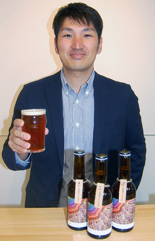クラフトビール「ふぞろいの麦たち」を手にする松尾浩久さん=京都市上京区で、国本ようこ撮影