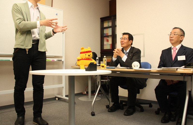 自己アピールに励む区議選の新人立候補予定者(左)。元衆院議員の早川忠孝弁護士(中央)が厳しい視線を送る=東京都豊島区で、飯田憲撮影