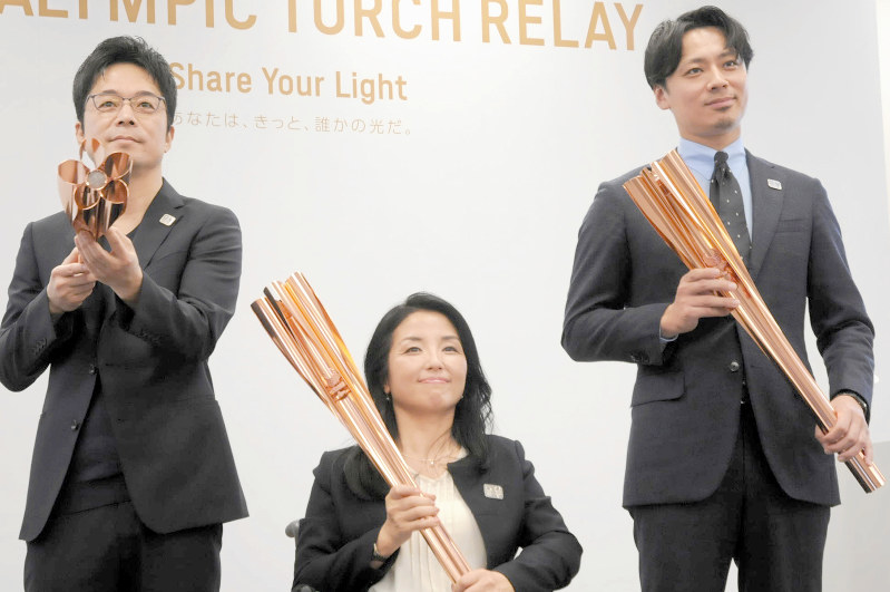 聖火リレートーチをお披露目する(左から)デザイナーの吉岡徳仁さん、広報大使の田口亜希さん、アスリート委員の池田信太郎さん=東京都港区で2019年3月25日