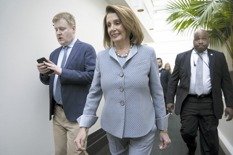 所属議員を集めた非公開会合に向かう民主党のペロシ下院議長=ワシントンで26日、AP