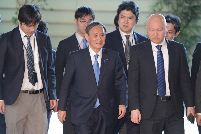 首相官邸に入り記者に囲まれる菅義偉官房長官=首相官邸で2019年4月1日午前8時34分、川田雅浩撮影