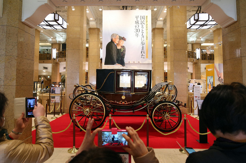 天皇、皇后両陛下の結婚パレードで使われたものと同型の儀装馬車を撮影する来場者ら=東京都中央区で2019年4月3日午前10時40分、小川昌宏撮影
