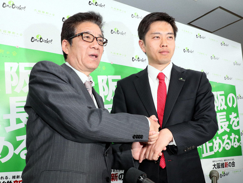 大阪府知事選・大阪市長選でそれぞれ当選確実となり、握手する吉村洋文氏(右)と松井一郎氏=大阪市中央区で2019年4月7日午後8時55分、幾島健太郎撮影