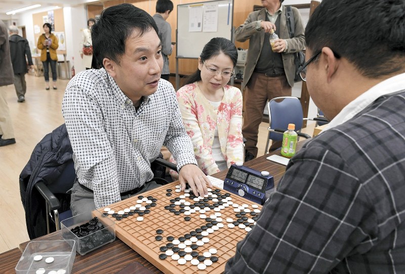 感想戦で対局を振り返る中丸仁さん(左)。中央は妻由紀さん=東京都千代田区の日本棋院で2019年4月7日、竹内紀臣撮影