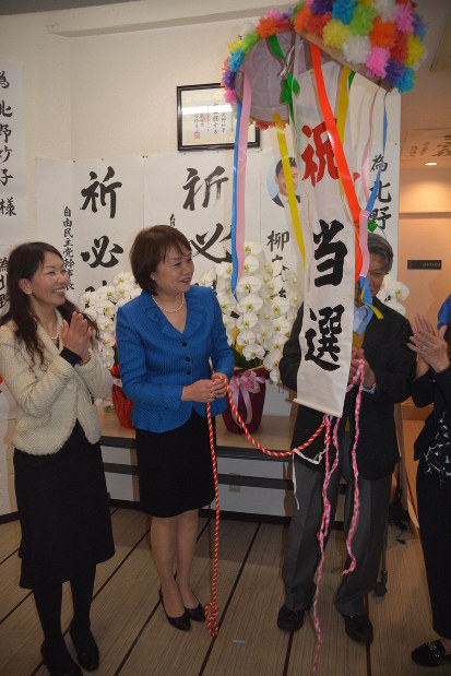 支援者とくす玉を割って喜び合う北野妙子さん（中央）＝大阪市淀川区で8日午前0時31分、松浦吉剛撮影