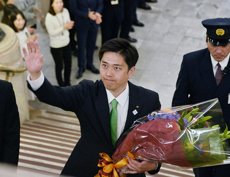 花束を手に、出迎えた職員らに手を振る吉村洋文大阪府知事=同府庁で2019年4月8日、加古信志撮影