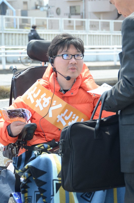 通行人に主張の内容を説明する渡辺さん=千葉市花見川区のJR幕張本郷駅前で2019年4月3日11時8分、斎藤文太郎撮影
