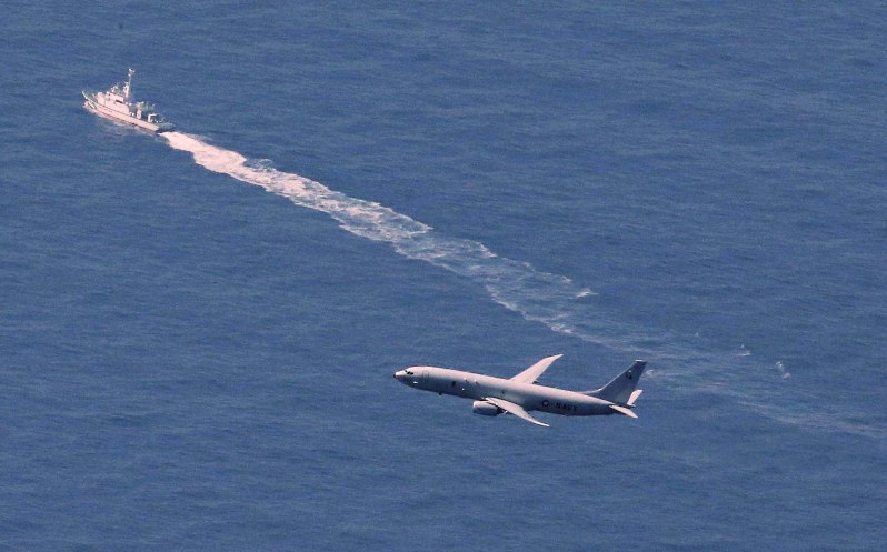 航空自衛隊三沢基地所属の最新鋭ステルス戦闘機F35Aが墜落した海域付近を捜索する米軍の航空機(手前)と海上保安庁の船舶=青森県沖で2019年4月10日午前9時46分、本社機「希望」から玉城達郎撮影