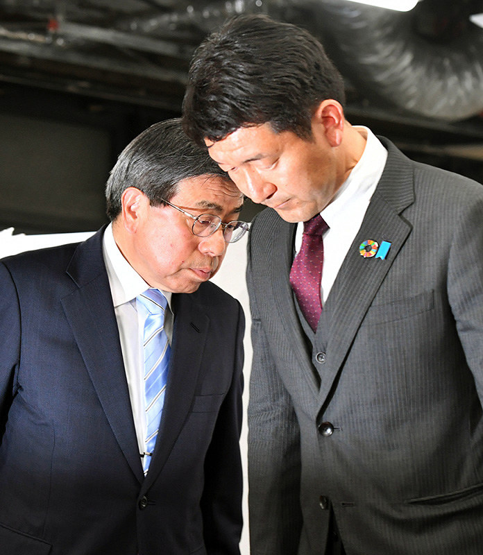 厳しい表情で支持者へのあいさつを終えた小西禎一氏(左)と柳本顕氏=大阪市中央区で2019年4月7日午後8時半、小松雄介撮影