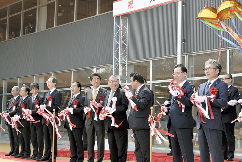 大熊町の新庁舎開庁をテープカットで祝う渡辺利綱町長(右から4人目)や安倍晋三首相(同5人目)ら=福島県大熊町大川原で14日