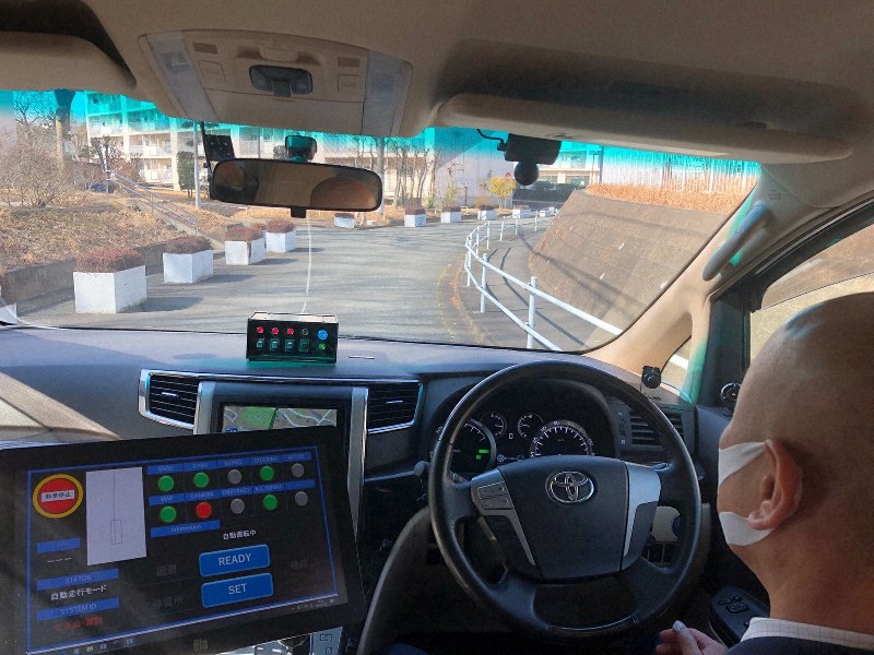 多摩ニュータウンの団地内を走る自動運転車。緊急時に備えて乗務員がハンドルに手を添えている=東京都多摩市で2019年2月23日、清水憲司撮影