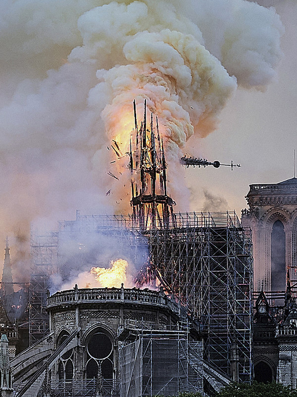 炎を上げて崩れ落ちるノートルダム大聖堂の尖塔=パリで2019年4月15日、AP