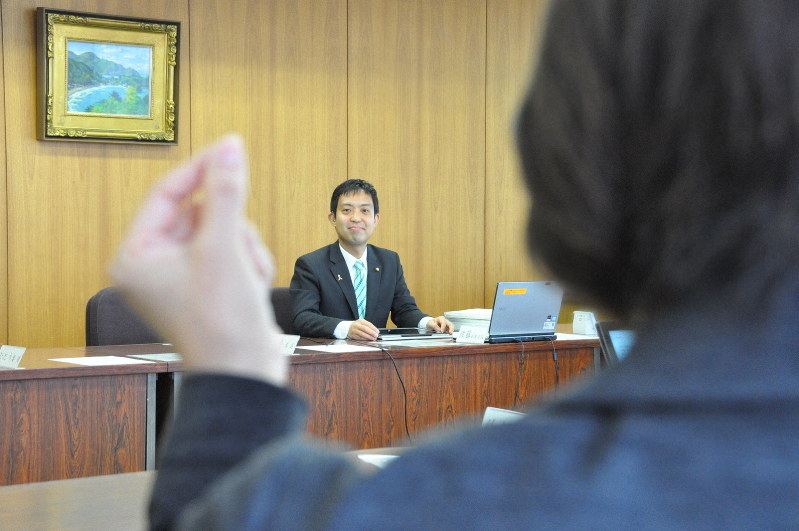 手話通訳者(手前)と音声を文字にするシステムでの支援を受ける佐藤太信市議=埼玉県戸田市議会で2019年3月11日9時44分、成田有佳撮影