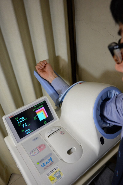 自動血圧計で血圧を測る様子。降圧目標の引き下げにより、高血圧の治療や健康管理への関心が高まりそうだ＝東京都千代田区で2019年4月19日11時33分、野田武撮影