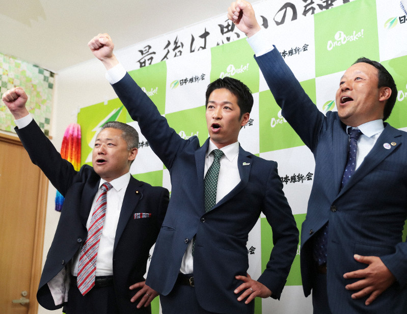 衆院大阪12区補選で当選確実となり、拳を突き上げる藤田文武氏(中央)ら=大阪府寝屋川市で2019年4月21日午後9時42分、小出洋平撮影
