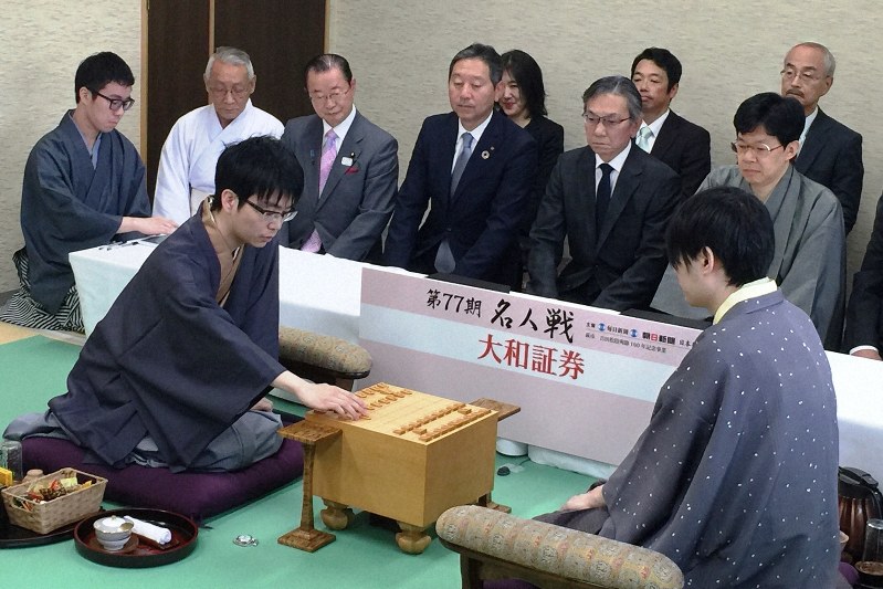 第77期名人戦七番勝負第2局で、初手の2六歩を指す豊島将之王位(手前左)。同右は佐藤天彦名人=山口県萩市の松陰神社で2019年4月22日午前9時、丸山進撮影