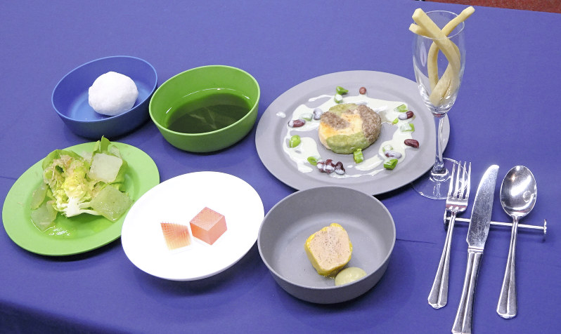 月で調達可能な食材で作った「月面ディナー」。上段中央の緑色のスープはミドリムシなどの藻類でできている=東京都中央区で、斎藤有香撮影