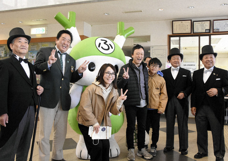 渋沢栄一に扮(ふん)したシルクハット姿の3人や小島進市長(左から2人目)らと写真を撮る来場客=埼玉県深谷市下手計の渋沢栄一記念館で2019年4月28日、大平明日香撮影