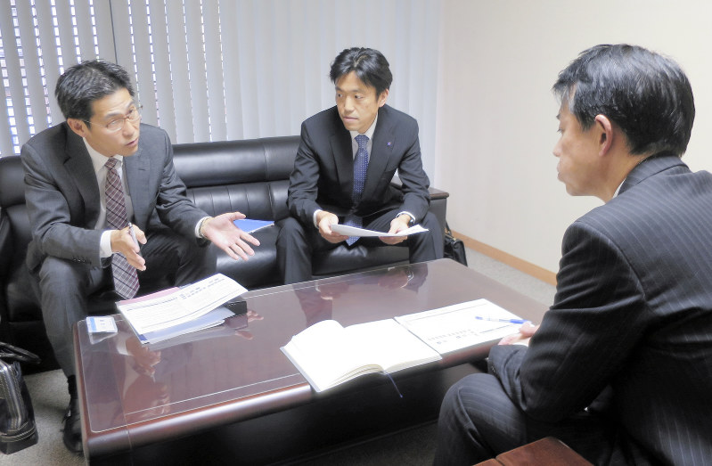 関西みらいフィナンシャルグループ各行の営業担当者同士で打ち合わせする紀平昌之(左)ら=神戸市のみなと銀行本店で2019年3月、小川祐希撮影