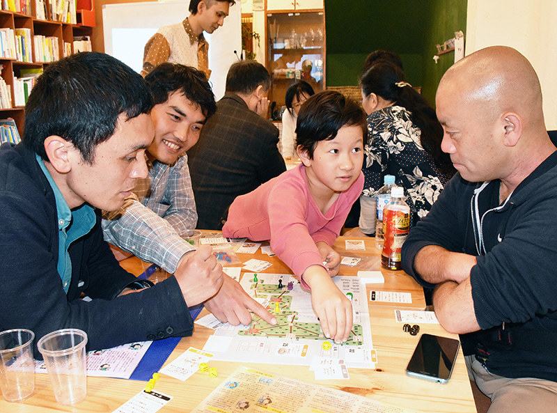 ボードゲームを楽しむ参加者たち=大阪市東淀川区西淡路1のコミュニティースペースで、隈元悠太撮影
